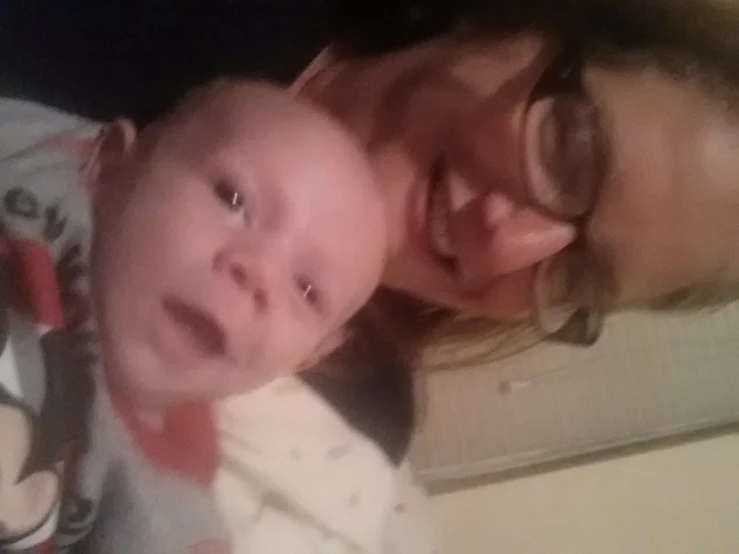 a woman holding a baby while taking a selfie