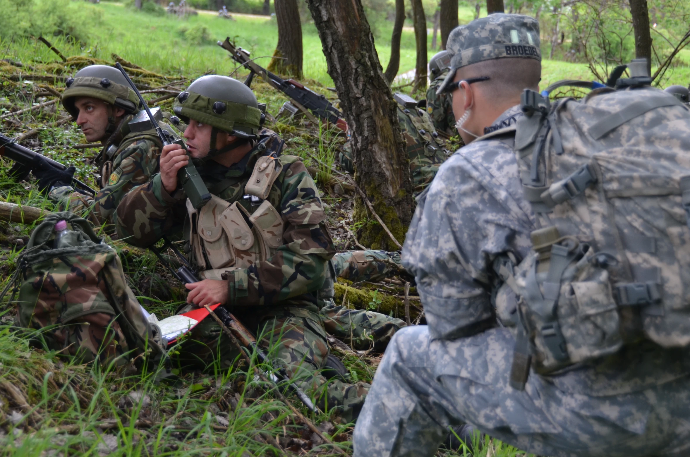 soldiers in camouflage are sitting in a field