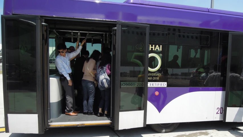 people standing on the open door of a bus