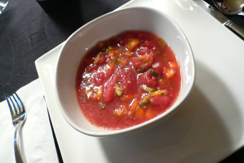 soup in bowl sitting on the table next to some utensils