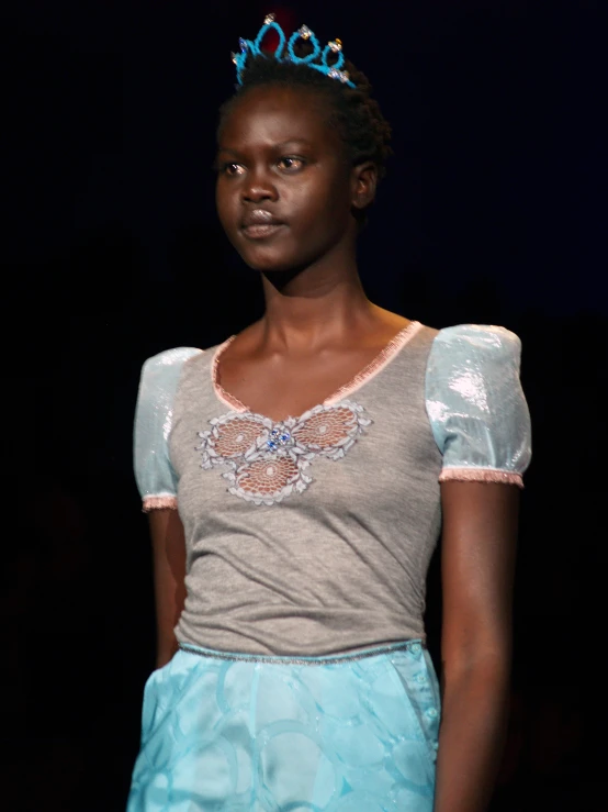 a young woman wearing a blue and grey dress