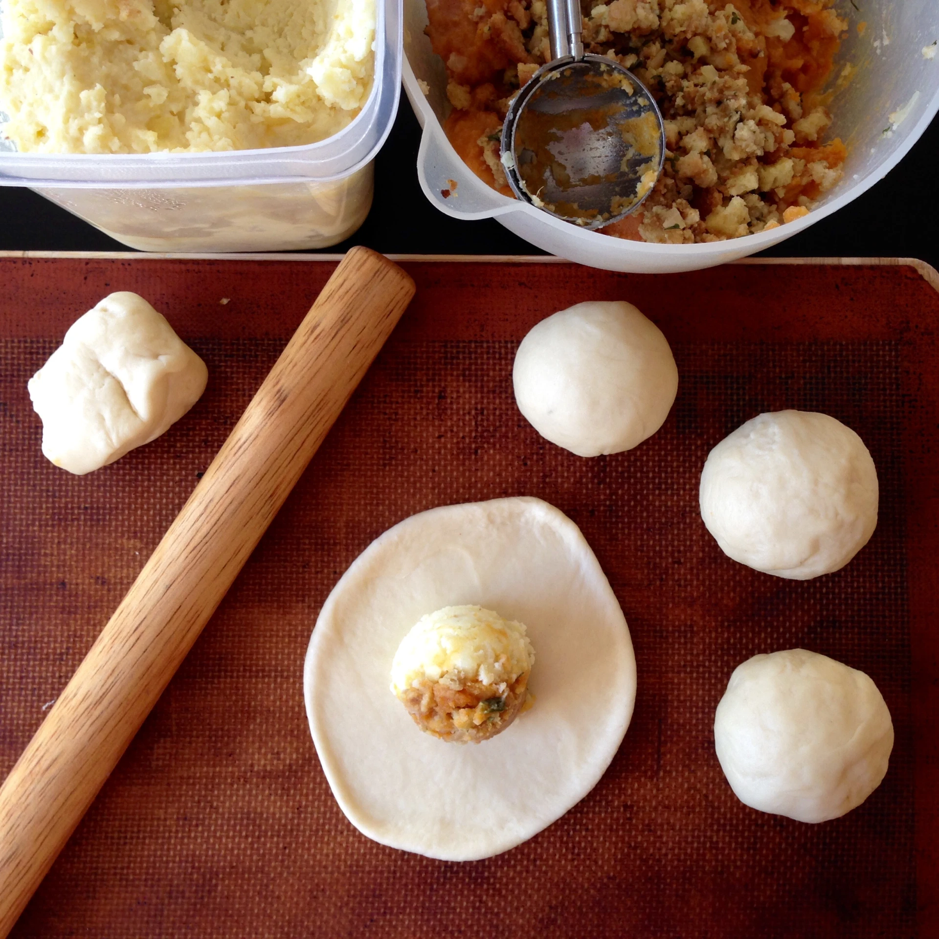 doughs being prepared for an appetizer in front of a pot with potatoes and mashed potatoes