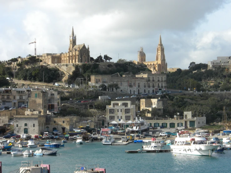 some boats docked in a harbor by a large castle