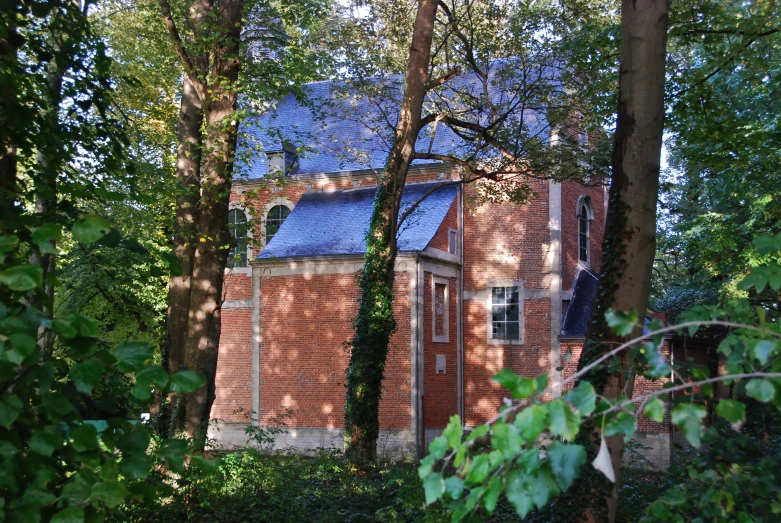 an old red brick house in the woods