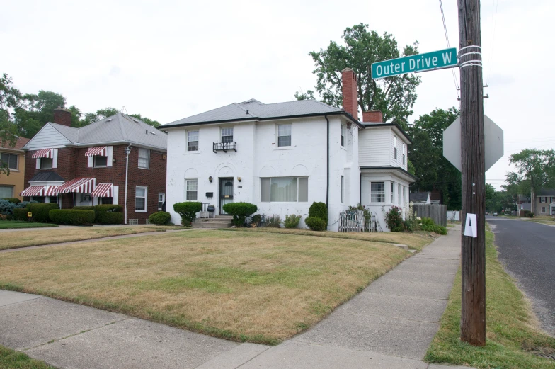 a street sign and stop sign are in front of an older brick building