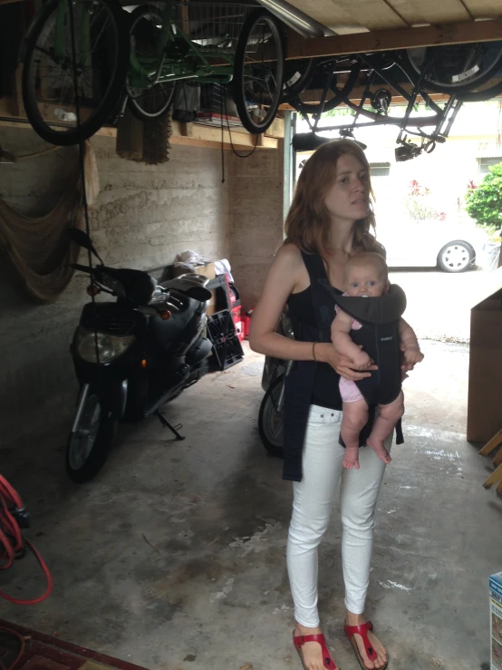 woman in black shirt holding baby in garage