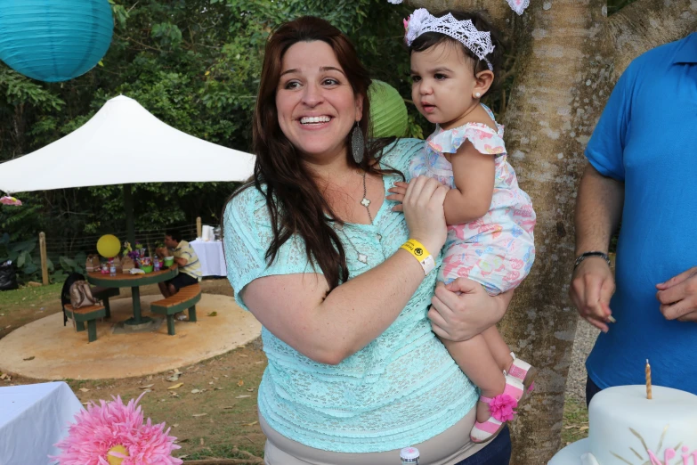 a woman is holding her child at a party