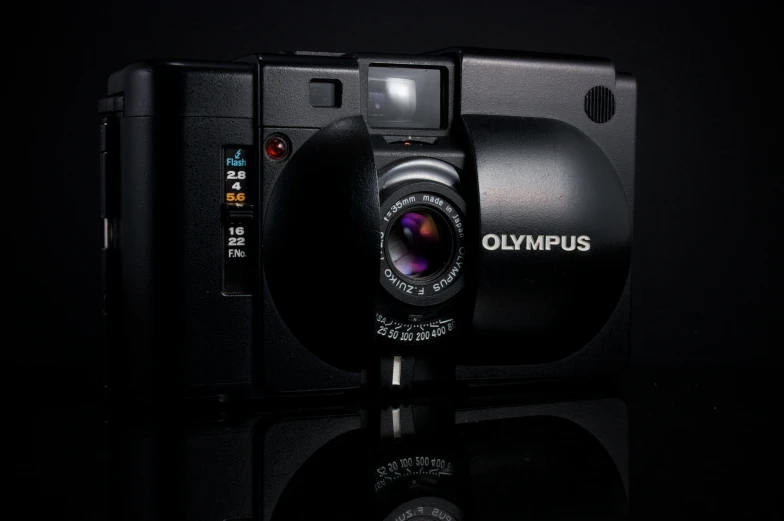 a black camera on a reflective surface with its lens