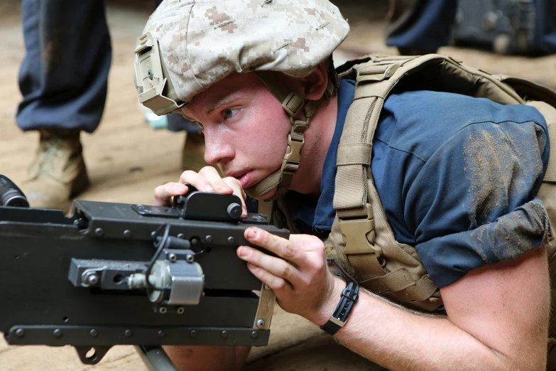 the man is wearing a cap and holding a gun