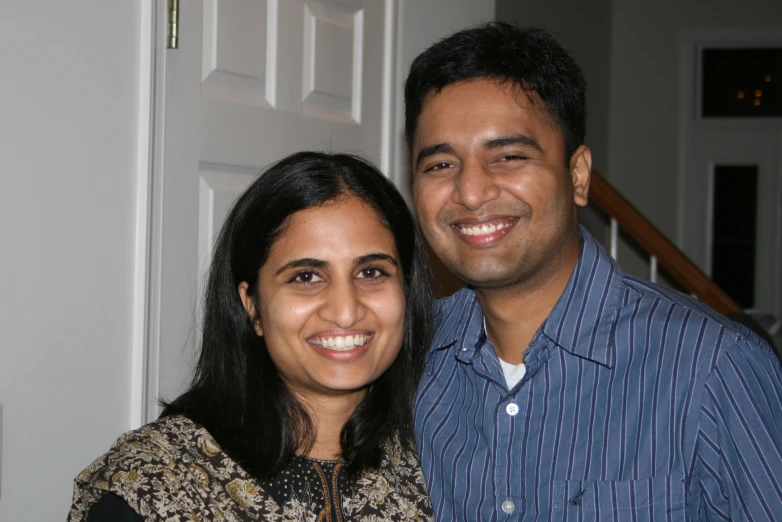 a smiling couple in front of a door