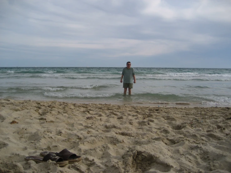 a man is standing in the water at a beach