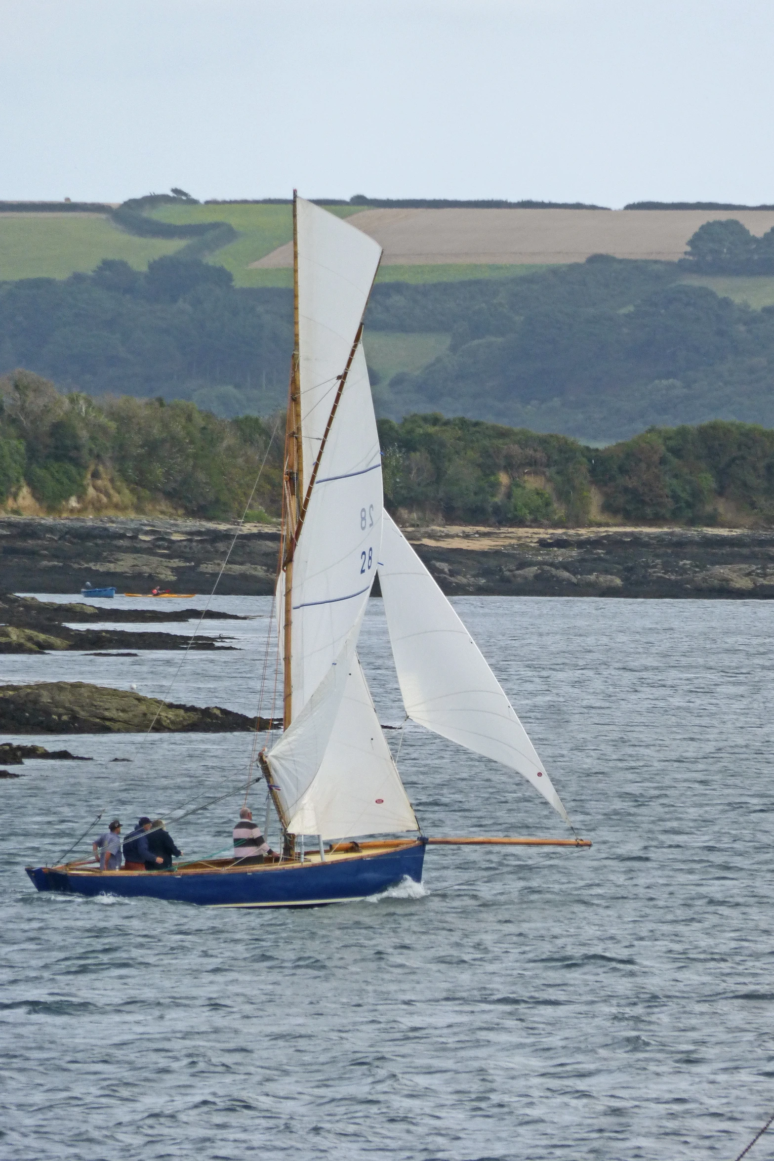 there is a small sailboat that has three people inside