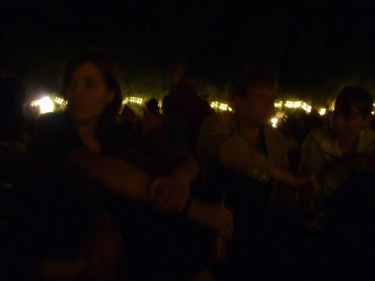 a woman with arms crossed looking down in the dark