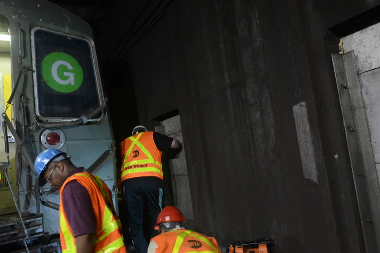 some men in safety gear near a big truck