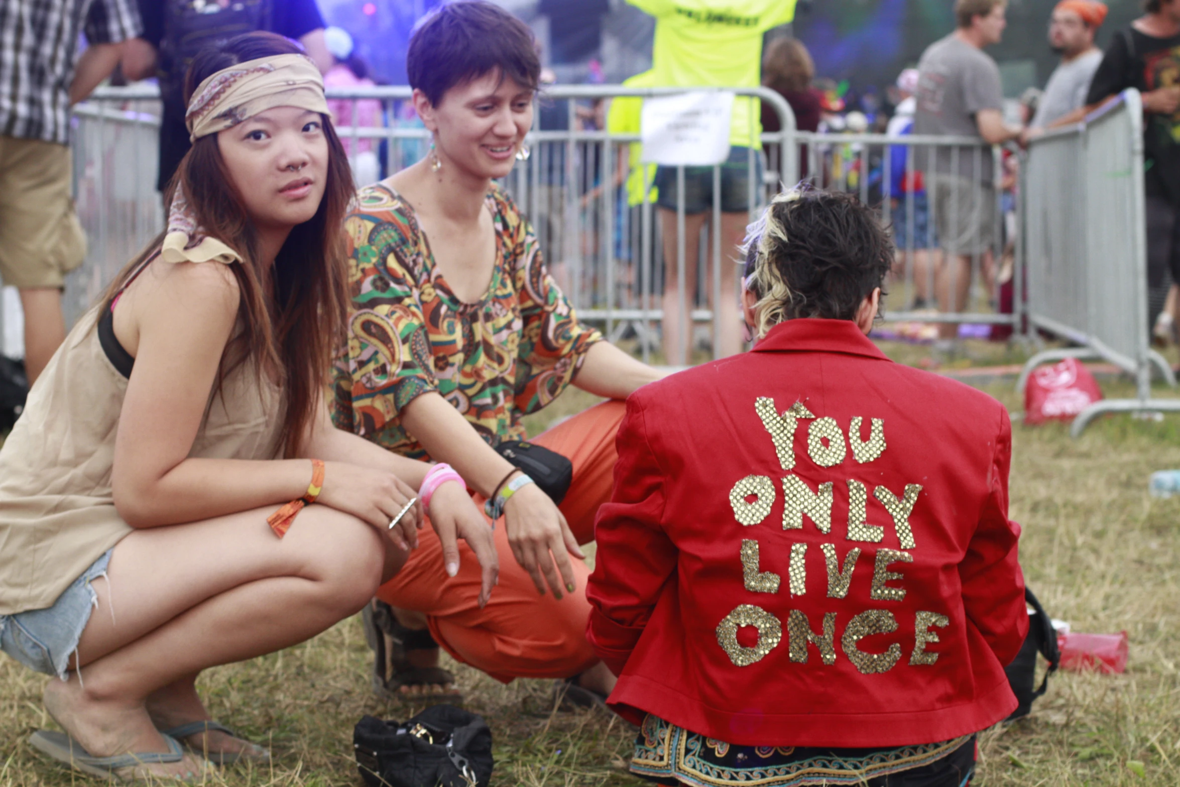 two girls are sitting and talking on the grass