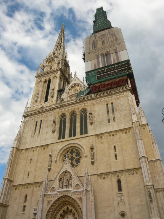 the tower of a large building under a cloudy sky