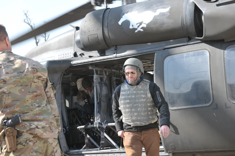 two men in uniform and a helicopter with military insignia