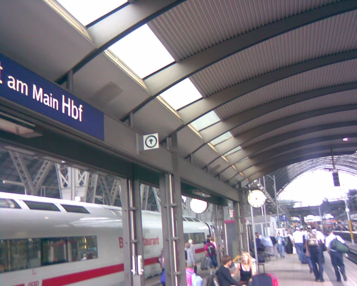 many people are walking outside a train station