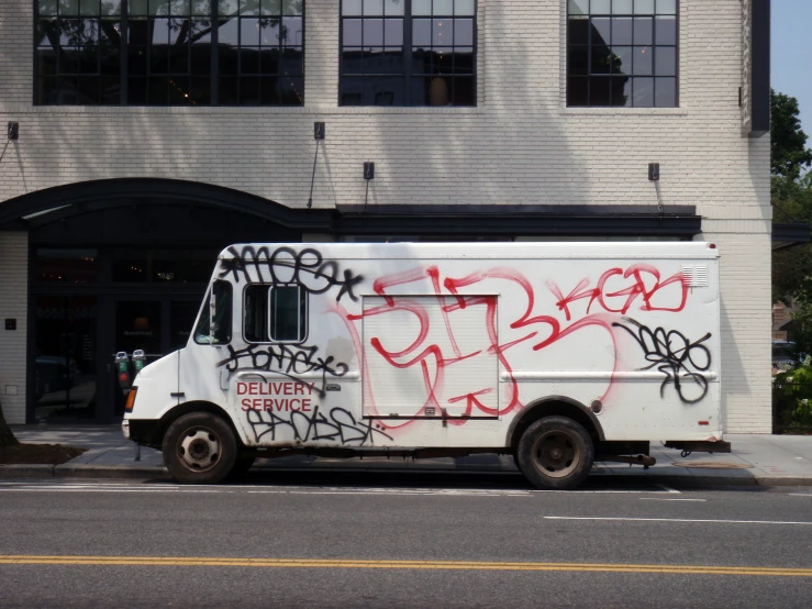 a truck with graffiti sitting on a street