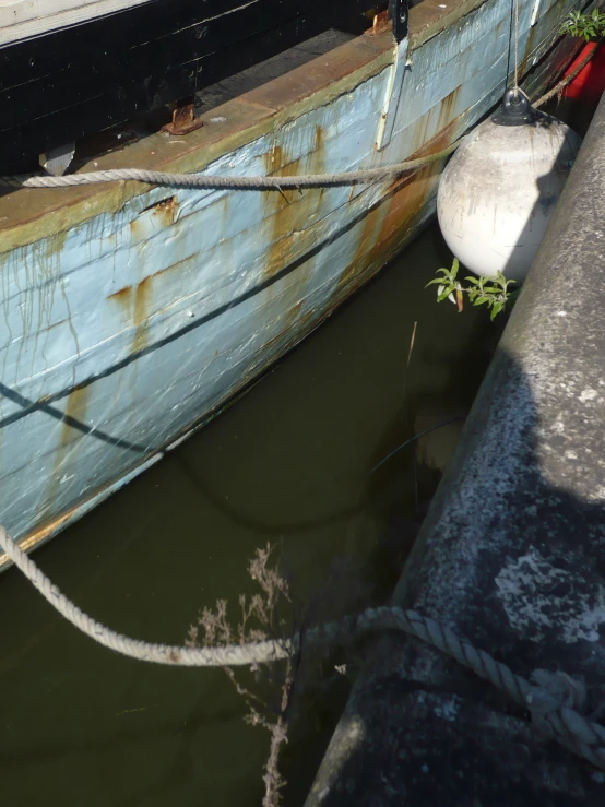 the old, weathered boat is in the water