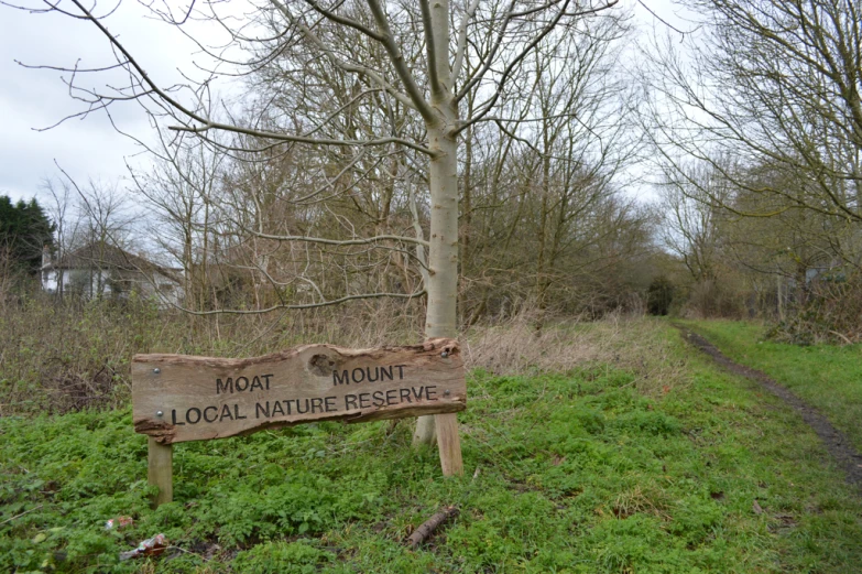 a sign sitting on the side of a dirt road