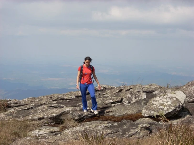 woman with red shirt on a rocky mountain top