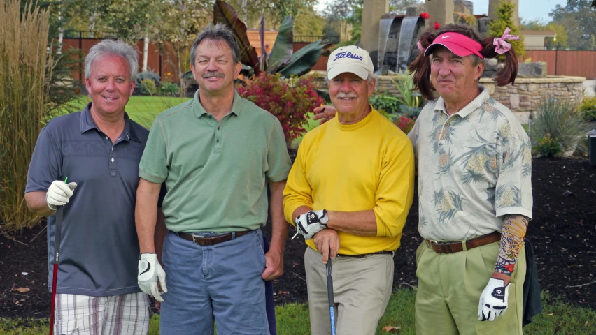 a few golfers posing for a picture with the man behind them