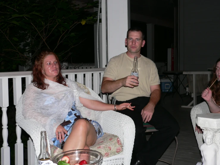 a man and a woman are sitting on a porch and talking