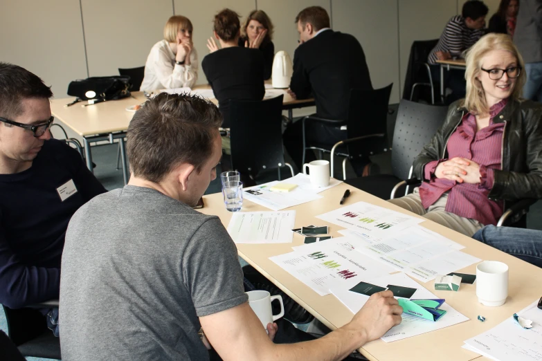 a group of people sitting at a table looking over their papers