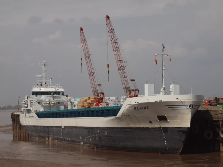 a large ship is docked with a crane