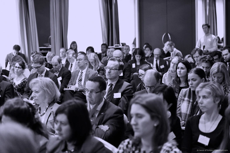 people are listening to an event at a conference