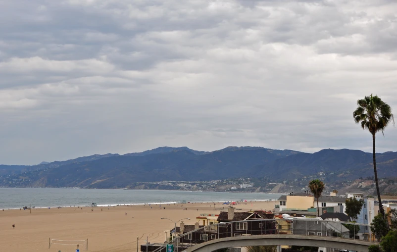 an aerial view of a beach with mountains in the background