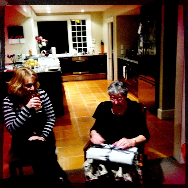 two women talking in a kitchen at night