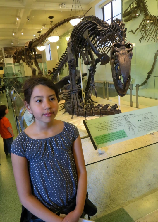 the girl is standing in front of the museum exhibit