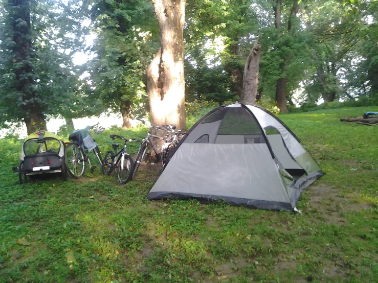 a tent with a bicycle next to it on the grass