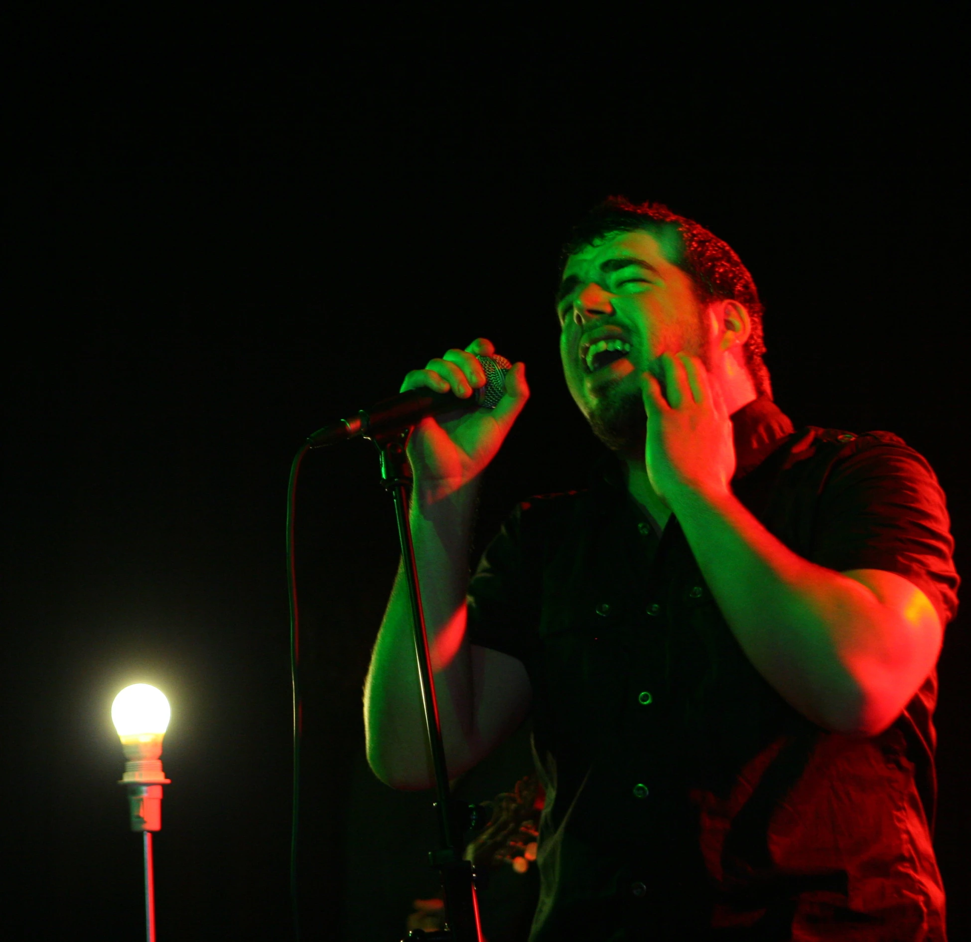 the man is singing in front of his microphone