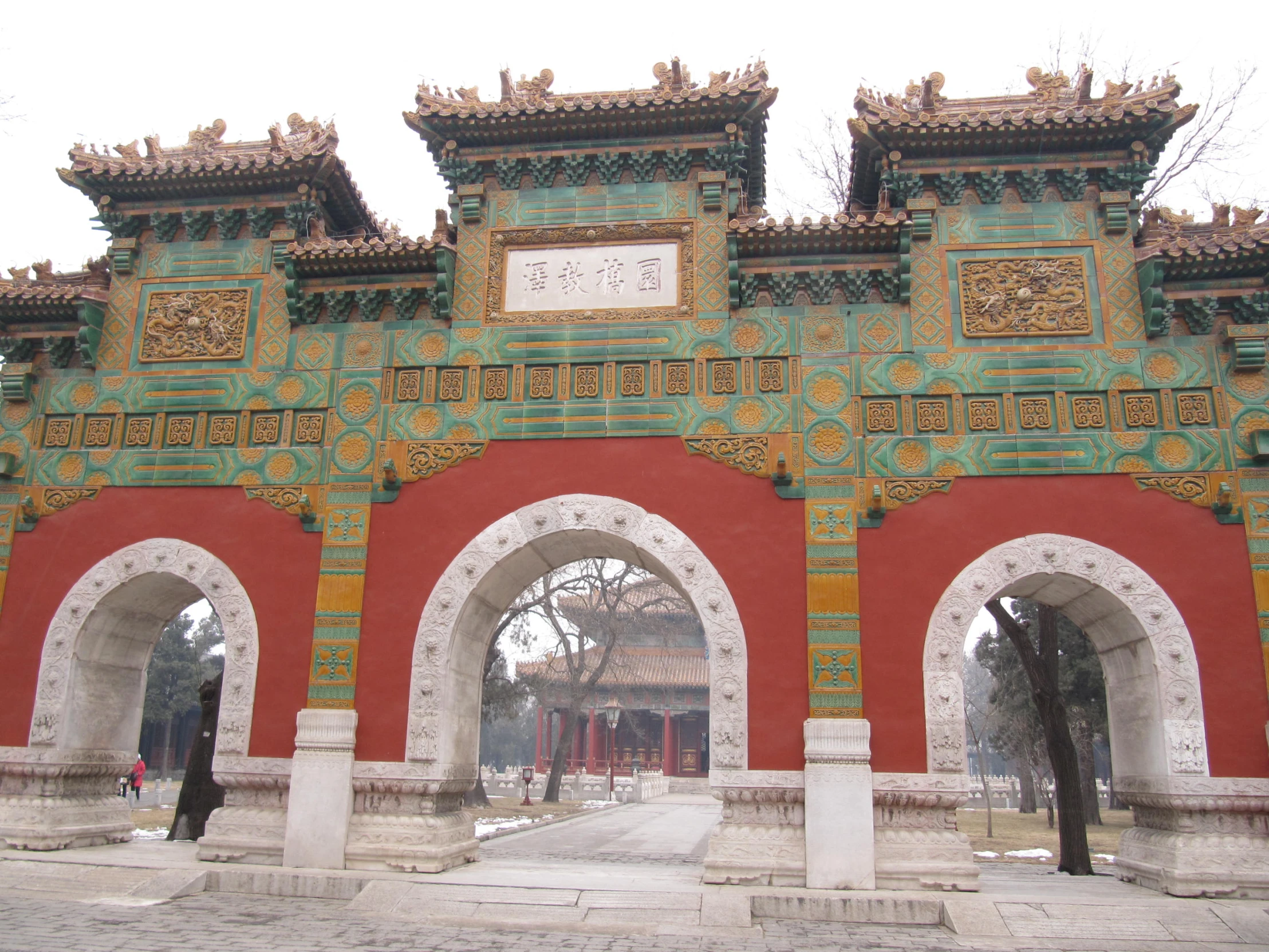 an ornate gate that has gold and green decorations on top