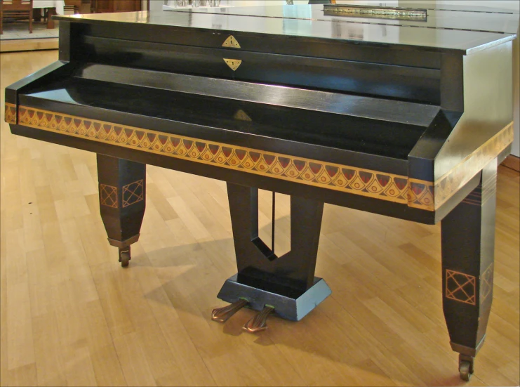 a large black piano is on a hard wood floor