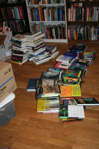 large collection of books on a wood floor in a liry