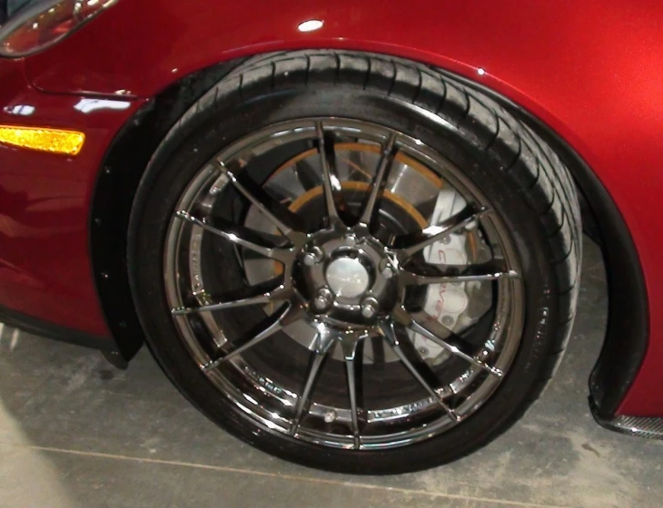 the rims on a red sports car are seen