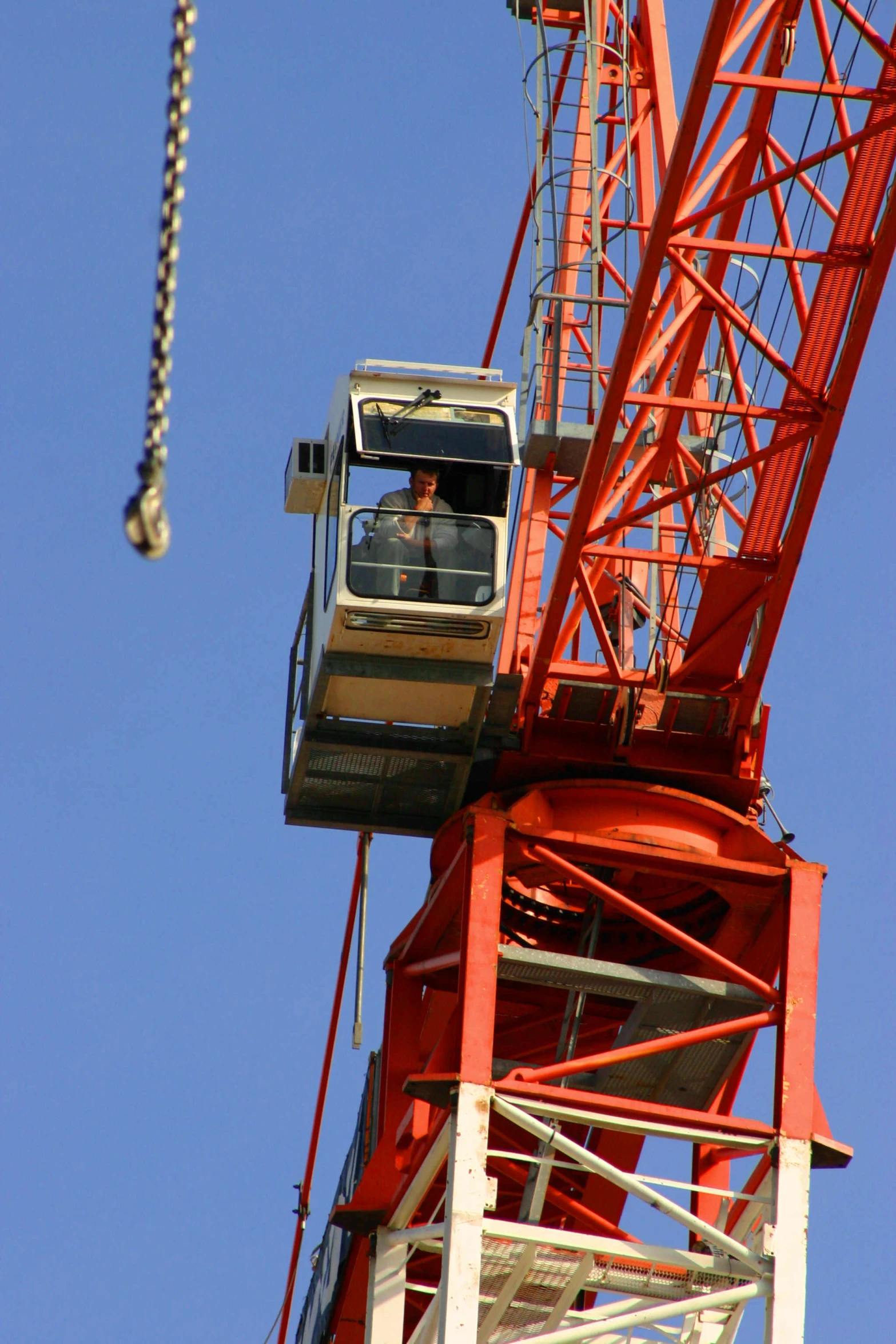 a man is sitting in the crane at the top of the building