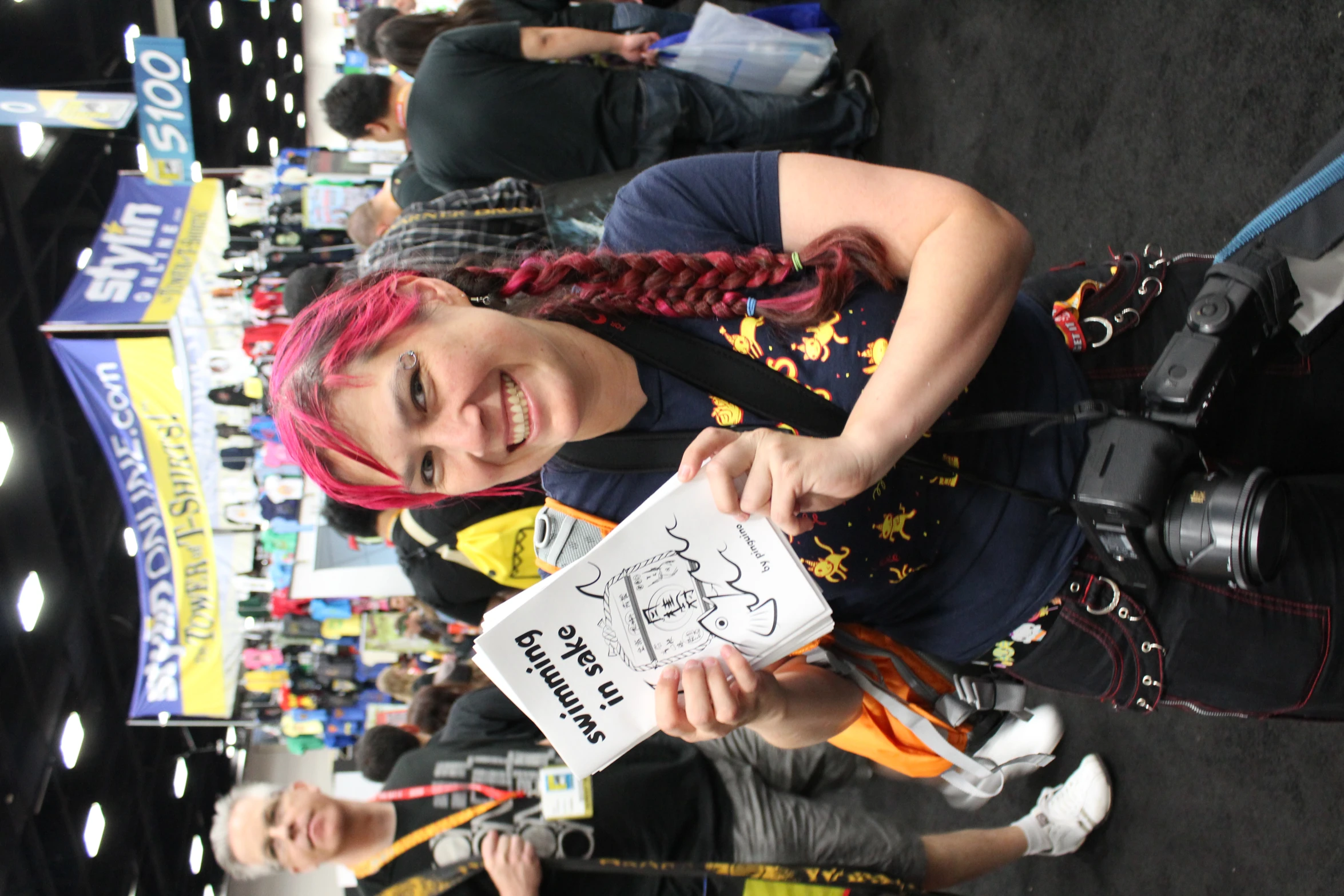 a woman with pink hair smiles as she poses for a po at the camera