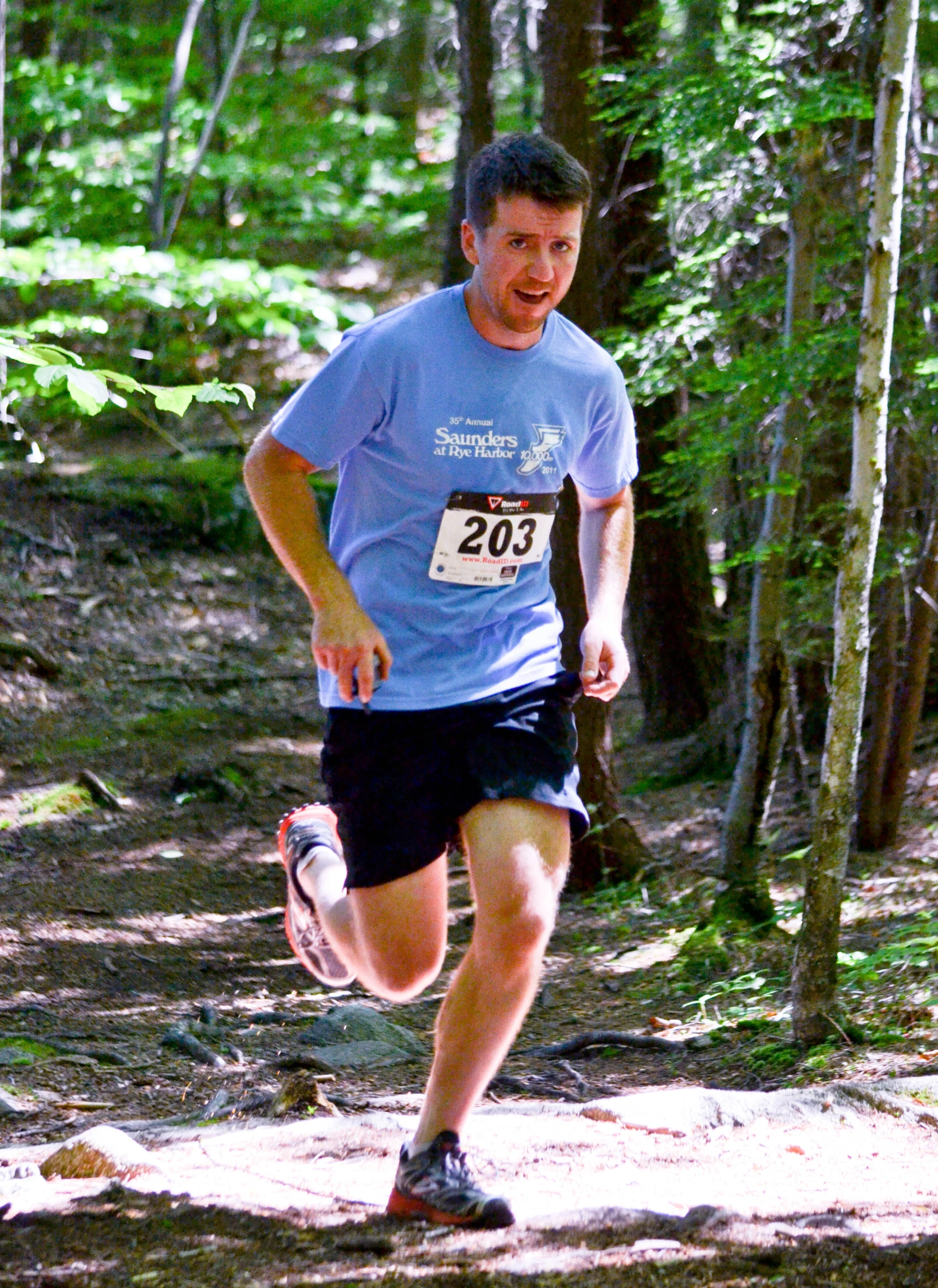 a man running in a trail in the woods