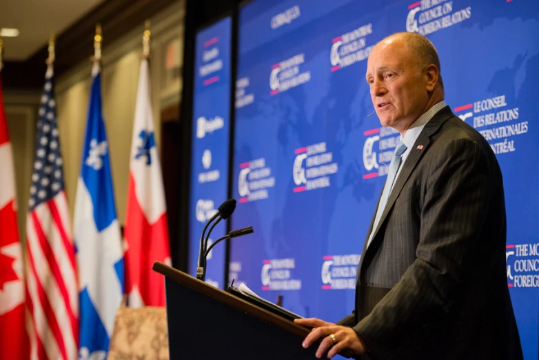 a man stands at a podium and speaks into a microphone