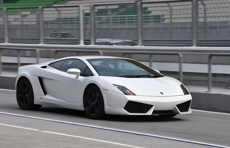 the white sports car is speeding along the track