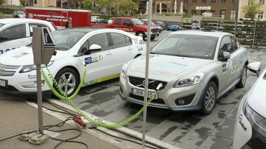 two cars are parked at a charging station