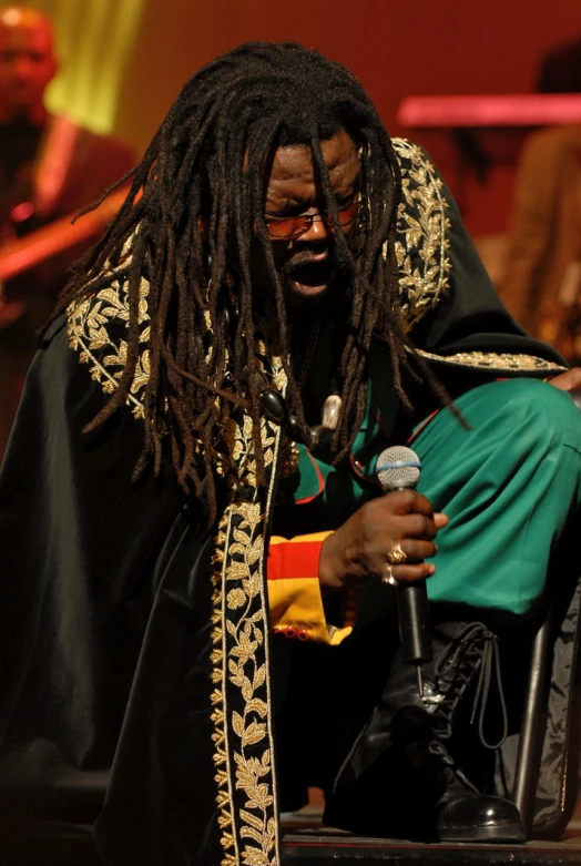 a man with dread locks speaking into a microphone