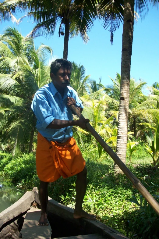 man on wooden raft with palm trees in the background