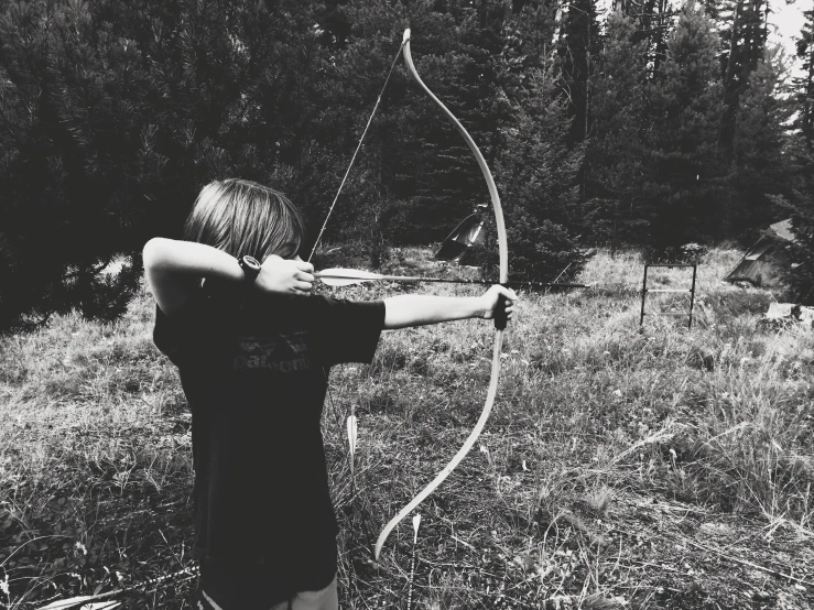 a person standing in a field with a bow