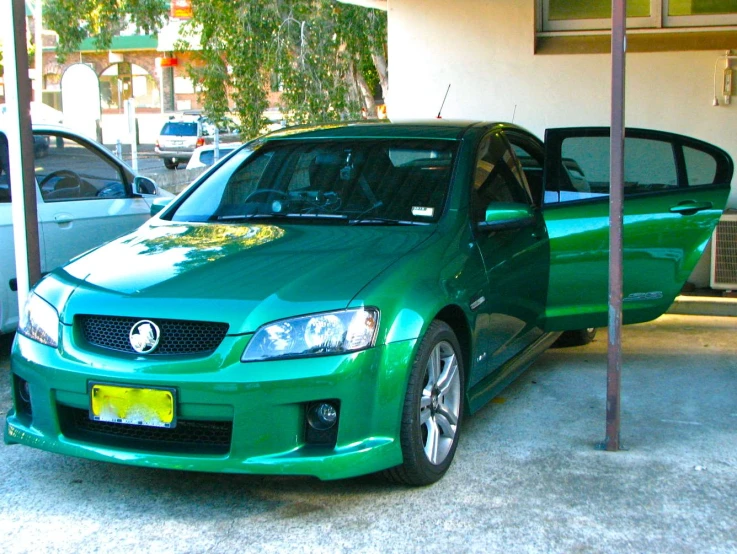 a green car that is parked outside a house